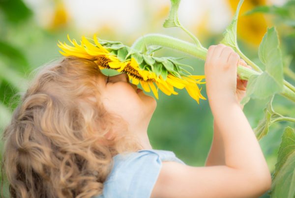 happy child on autism spectrum with flower