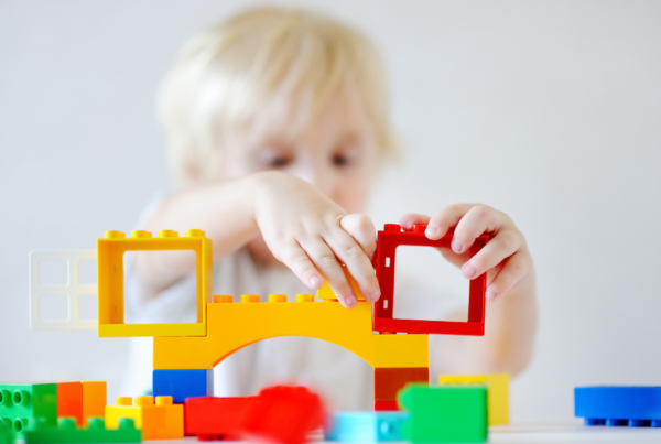 child building with legos using fine motor skills